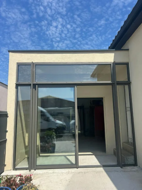 Sas d'entrée châssis coulissant et fixes Terra gris désert aluminium Profils Systèmes Saint-Julien-les-Rosiers vue extérieure