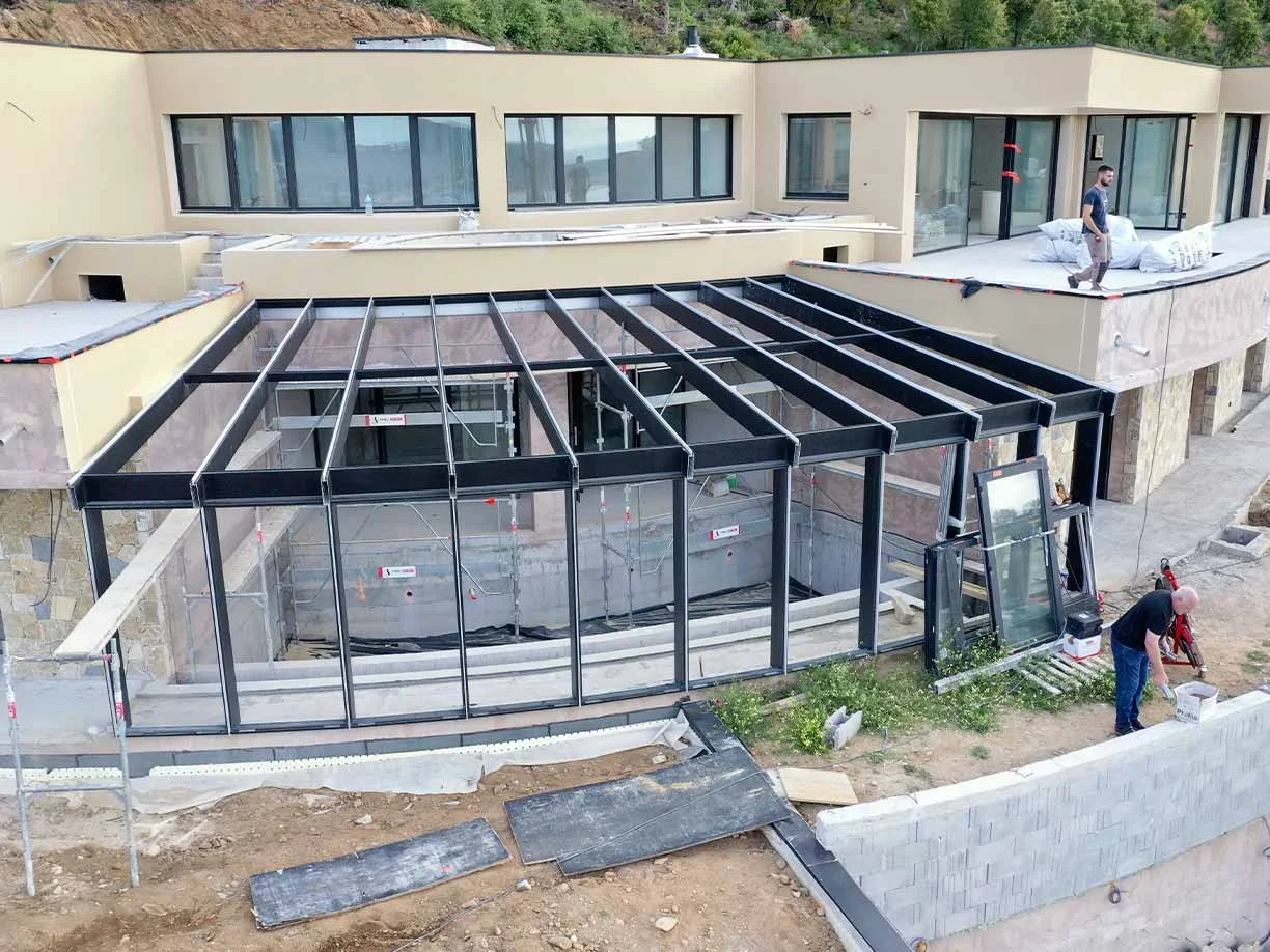 Pose de la verrière autour d'une piscine dans villa en construction